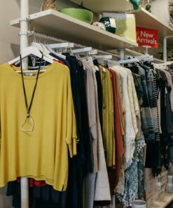 Interior of a fashion boutique with clothes elegantly displayed on racks and shelves.