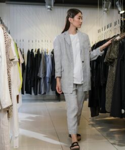 Young woman browsing clothes in modern fashion boutique.